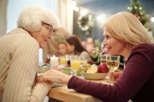Senior Woman and Adult Daughter Connecting at Christmas Dinner_Holidays and Dementia