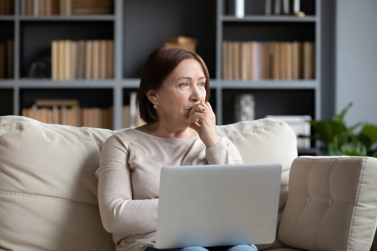 Senior Woman with Laptop Thinking on Couch_Memory Loss