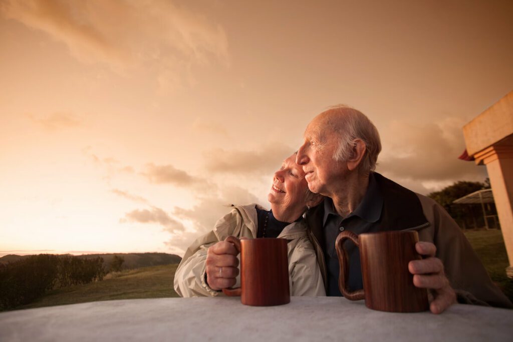 Married couple of older adults watching the sunset