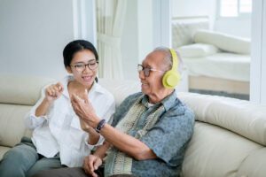 Caregiver putting music to an older adult