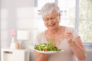 Happy older woman eating healthy