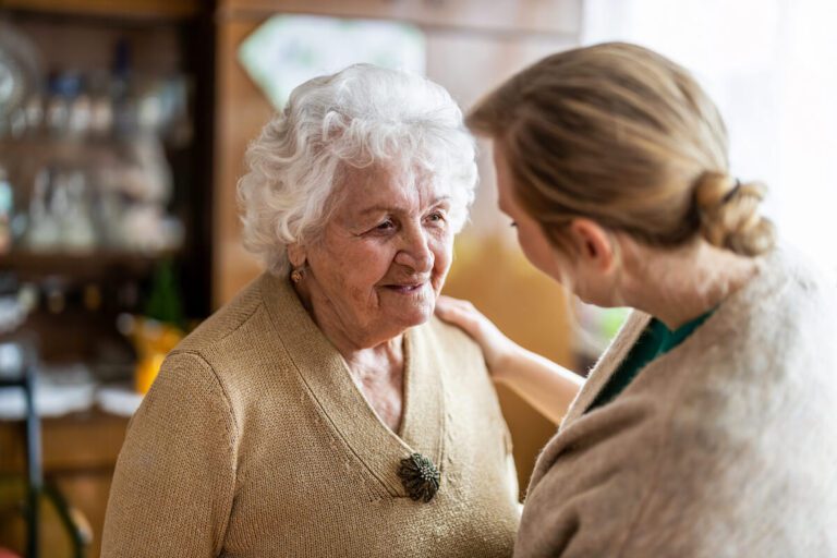 Caregiver comforting an older woman with dementia