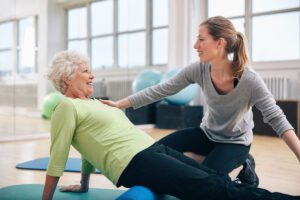 Caregiver helping an older woman exercise