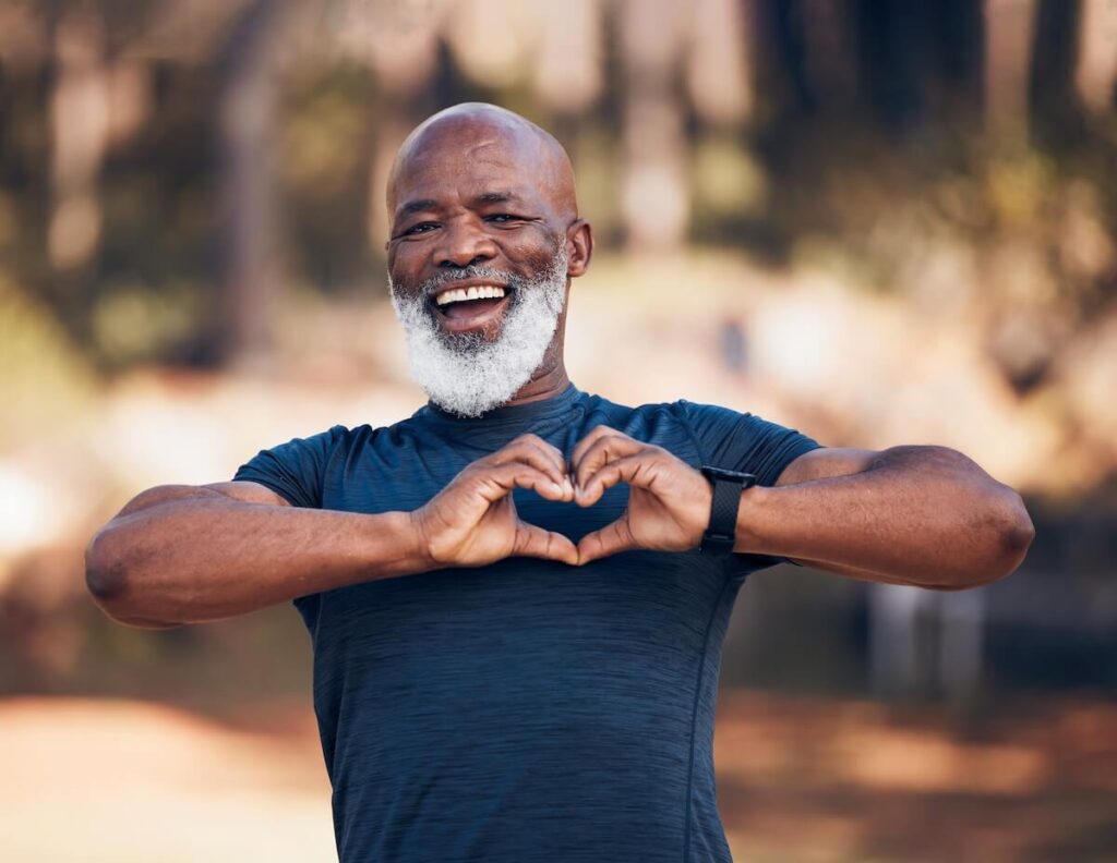 Older man making a heart hand sign in an assisted living community