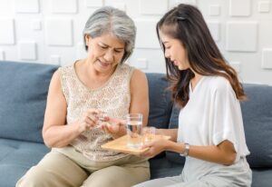 Senior living caregiver helping manage an older woman's medications